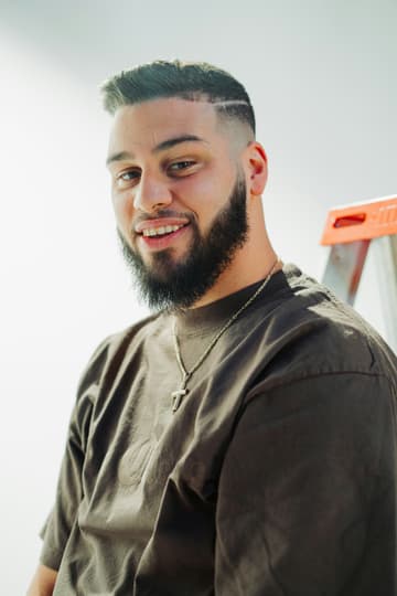 Profesional sonriendo junto a su escalera de trabajo